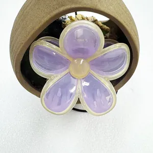Detailed close-up of a purple jelly frangipani flower hair claw clip with yellow accents