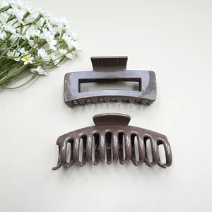 Detail view of glossy dark brown shark hair clips in rectangular and curved designs
