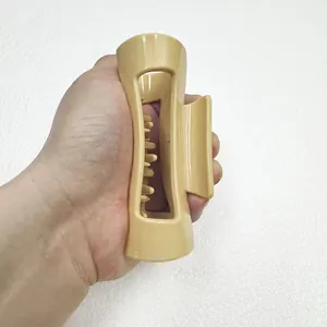Detail view of large cream-beige silicone shark hair claw clip for thick hair