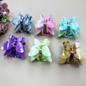 Detail view of 6 colorful butterfly hair claws with marble texture and metal spring