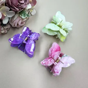 Detailed close-up of a 3-piece set of butterfly hair claws with marble texture