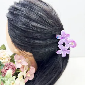Vue détaillée de la pince à cheveux double fleur de frangipanier violette sur cheveux