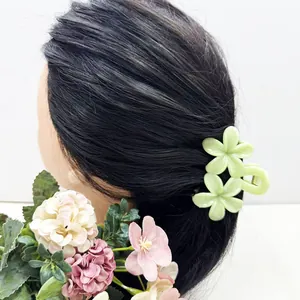 Détail de la pince à cheveux en forme de double fleur de frangipanier vert clair