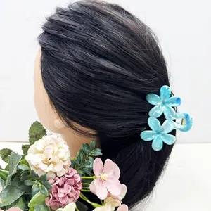 Détail de la pince à cheveux bleue à motif floral avec texture marbrée et ressort en métal