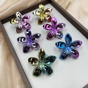 Metallic plated plumeria flower hair clips in vibrant gradient colors on satin background