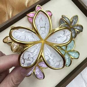 Elegante pinza per capelli a fiore con bordi in metallo dorato e trama a fessura fine