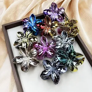 Detailed macro view of plumeria flower hair claws in metallic gold and purple finishes
