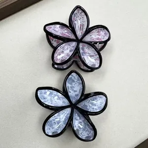Detail of floral claw clips with ink-wash patterns and black-edged petal designs