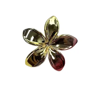 Elegant gold plumeria flower hair claw clip with pink gradient finish on white background