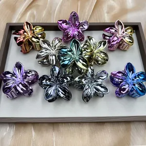 Plated metallic plumeria flower hair claws in multiple colors on elegant satin fabric