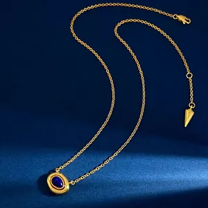 Macro shot of gold necklace with oval blue lapis lazuli pendant on blue velvet