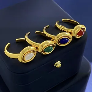 Macro shot of four vintage gold oval rings with red, green, blue and white gemstones