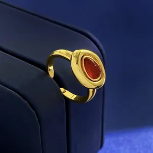 Detail of vintage gold-plated open ring featuring a teardrop red agate stone inlay