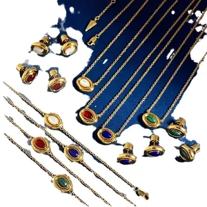 Vintage gold oval jewelry set with red agate and malachite stones on an artistic background