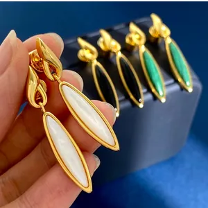 Dettaglio di orecchini lunghi a marquise con inserto in madreperla bianca e metallo