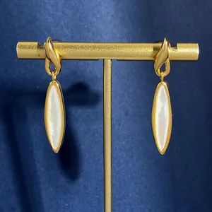 Orecchini vintage in oro con pendenti in madreperla marquise su sfondo in velluto blu