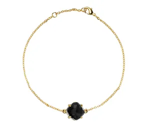 Detail van gouden kettingarmband met zwarte facetgeslepen kristal in een vierpootzetting