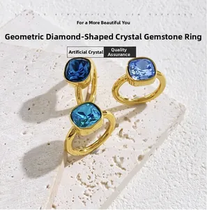 Close-up of three geometric square blue crystal rings set on a white stone base