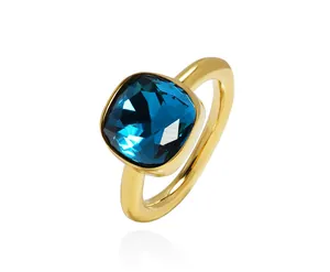 Detail of cushion-cut blue crystal ring with gold bezel setting and polished band