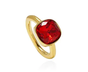 Macro detail of red square gemstone ring with polished gold setting and mirror reflection