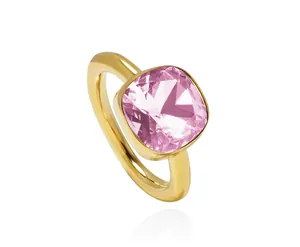 Macro view of pink cushion-cut crystal ring with golden band and mirror reflection