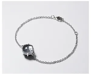 Detail van een zilveren armband met een gefacetteerd grijs kristal in een 4-klauw zetting
