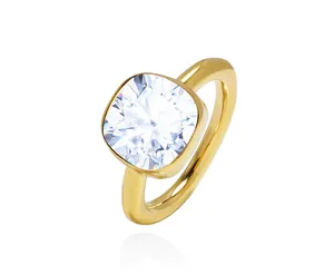 Macro shot of a sparkling cushion cut crystal set in a polished gold bezel ring setting
