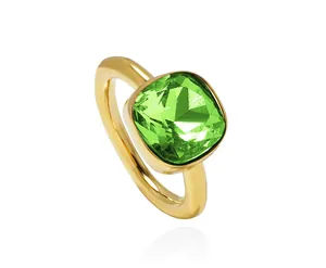 Macro detail of square emerald green crystal set in a polished gold plated ring band