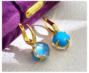 Details von Goldohrringen mit facettiertem hellblauem Kristall und Türkissteinen