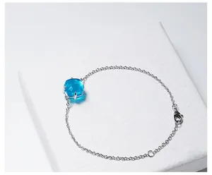 Macro-opname van de zilveren armband met vierkant geslepen blauwe kristal in een klauwzetting