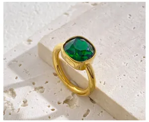 Macro detail of luxury square-cut green gemstone ring set on a white textured rock