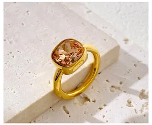 Macro shot of faceted champagne square gemstone ring on textured natural stone background