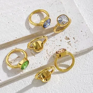 Set of minimalist square-cut crystal rings in vibrant colors on stone display