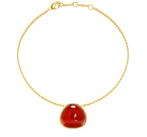 Close-up of a gold chain bracelet featuring a polished red agate stone in a bezel setting