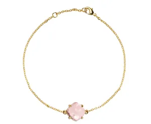 Detail van gouden armband met vierkant geslepen roze kristal in een vierklauwzetting