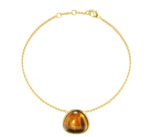 Macro view of gold chain bracelet with triangular tiger eye stone and lobster clasp