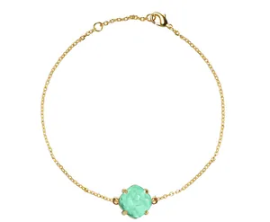 Macro-opname van gouden armband met een gefacetteerde mintgroene kristallen steen