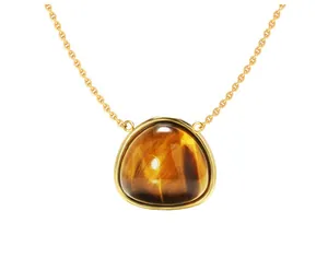 Detail shot of triangle tiger eye pendant with polished gold bezel on a fine chain