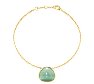 Detail of gold titanium steel bracelet featuring a triangular green gemstone pendant