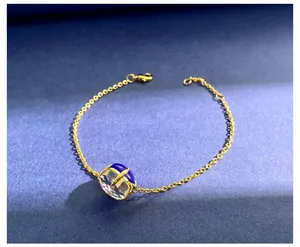 Detail van gouden armband met diepblauwe en heldere kristallen op blauwe achtergrond