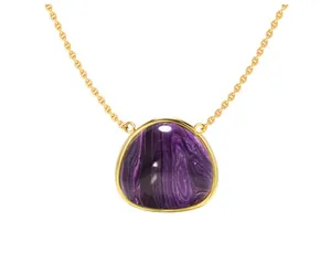 Macro detail of triangle purple gemstone pendant with polished gold plating on a fine chain