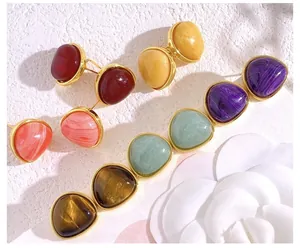 Detailed view of vintage-style stud earrings with colorful stones and gold metal borders