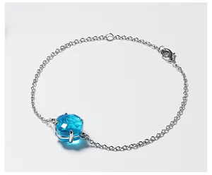 Macro-opname van een zilveren armband met een grote facetgeslepen blauwe vierkante steen