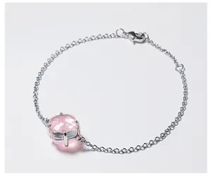 Detail van de zilveren kettingarmband met gefacetteerd roze kristal in een vierpootszetting