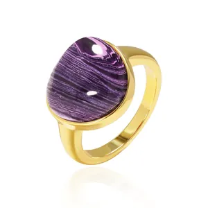 Polished gold stainless steel ring with a natural purple stone inlay on white background