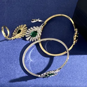 Detail eines Pfauenfedern-Armbands mit birnenförmigem Smaragd und Diamantenbesatz
