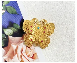 Vue détaillée de la broche papillon vintage avec filigrane doré et petites pierres