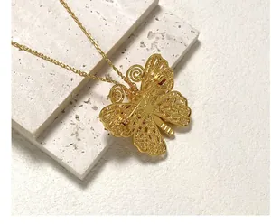 Détail d'une broche papillon dorée avec des ailes évidées et une épingle de fixation