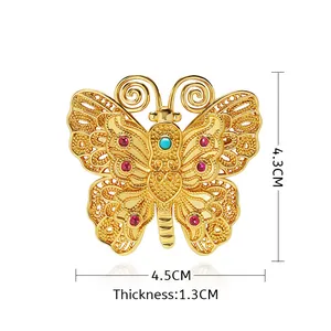 Broche papillon vintage dorée ornée de pierres rouges, bleues et de diamants fins