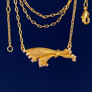 Italian brushed gold bow skirt pendant necklace with sparkling zircon stone accents